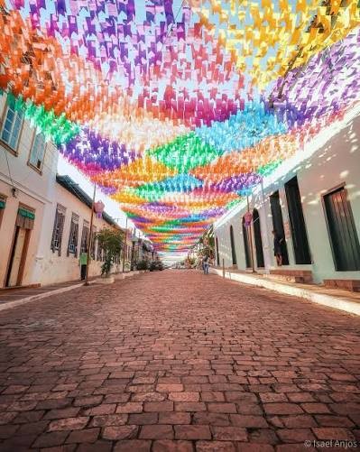 Rua de pedra do centro histórico de Mucugê enfeitada com bandeirolas coloridas